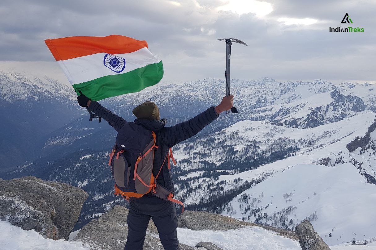 Hikers trekking through snow-covered Kedarkantha peak with scenic Himalayan views by IndianTreks.
